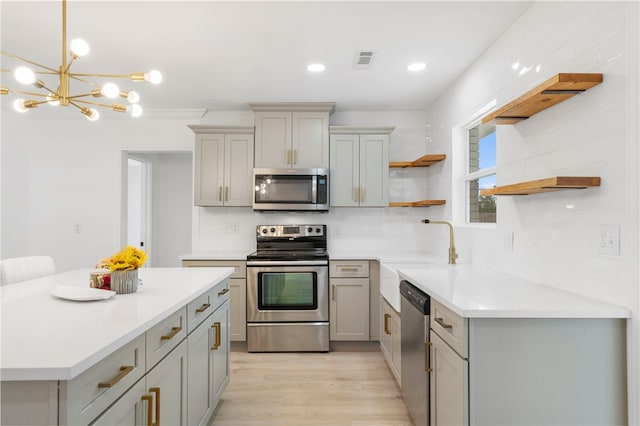 1089 Elway Dr, Springdale, AR 72764 - kitchen featuring appliances with stainless steel finishes, open shelves, gray cabinetry, light wood finished floors, and light countertops