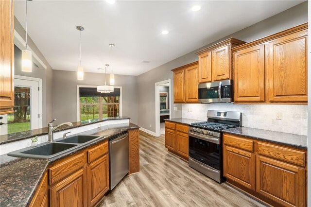 22704 Oakview Rd, Siloam Springs, AR 72761 - kitchen with appliances with stainless steel finishes, a sink, backsplash, light wood-style floors, and brown cabinetry