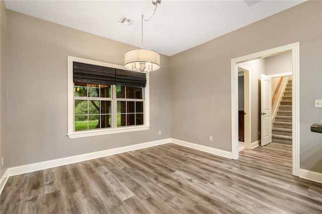 22704 Oakview Rd, Siloam Springs, AR 72761 - spare room featuring stairway, baseboards, wood finished floors, and a chandelier