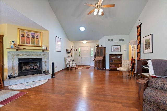 16 Osage Ln, Holiday Island, AR 72631 - living area featuring vaulted ceiling, ceiling fan, wood finished floors, a premium fireplace, and baseboards