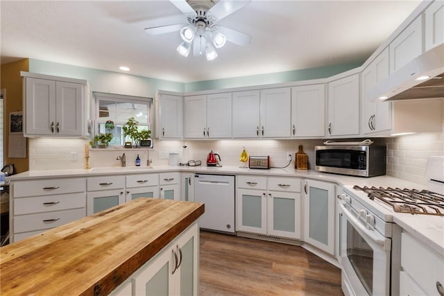 16 Osage Ln, Holiday Island, AR 72631 - kitchen featuring white appliances, a sink, wall chimney range hood, wooden counters, and a ceiling fan