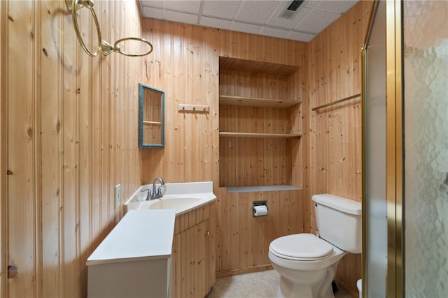 16 Osage Ln, Holiday Island, AR 72631 - bathroom featuring toilet, vanity, wood walls, and a drop ceiling