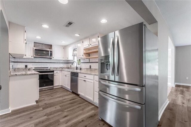 2182 Shumate, Springdale, AR 72762 - kitchen featuring appliances with stainless steel finishes, open shelves, a sink, wood finished floors, and white cabinets