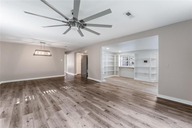 2182 Shumate, Springdale, AR 72762 - unfurnished living room with a ceiling fan, wood finished floors, baseboards, and a chandelier