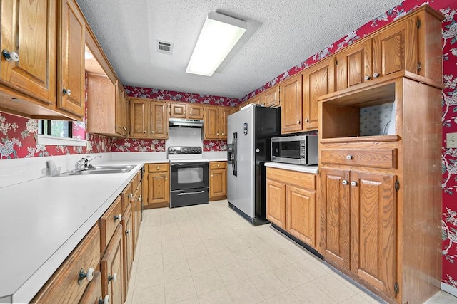 634 Orchard View Ests, Alma, AR 72921 - kitchen with appliances with stainless steel finishes, under cabinet range hood, a textured ceiling, brown cabinetry, and light countertops