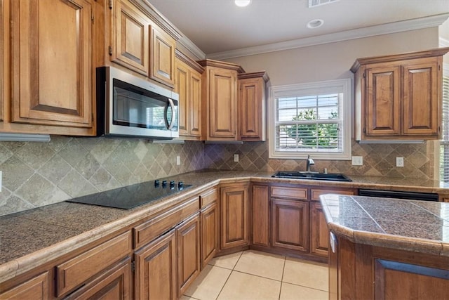 4204 Warbal Trl, Rogers, AR 72758 - kitchen with stainless steel microwave, black electric stovetop, brown cabinets, and ornamental molding
