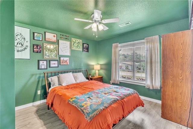 20640 Hillcrest Dr, Springdale, AR 72764 - bedroom featuring wood finished floors, a textured ceiling, baseboards, and ceiling fan