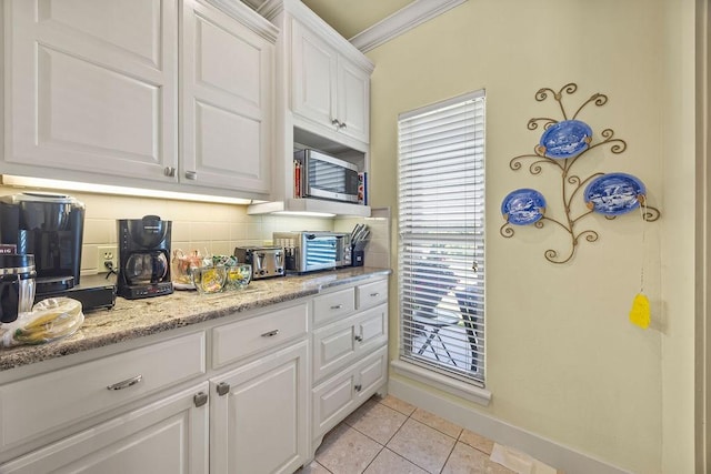 815 James Pl, West Fork, AR 72774 - kitchen with white cabinets, light tile patterned floors, ornamental molding, decorative backsplash, and stainless steel microwave
