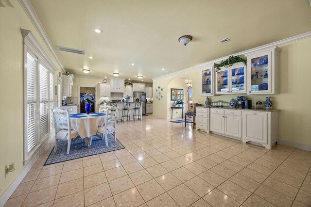 815 James Pl, West Fork, AR 72774 - dining area with light tile patterned flooring, crown molding, arched walkways, baseboards, and recessed lighting