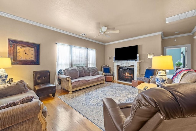 815 James Pl, West Fork, AR 72774 - living room with wood finished floors, a ceiling fan, a warm lit fireplace, and crown molding