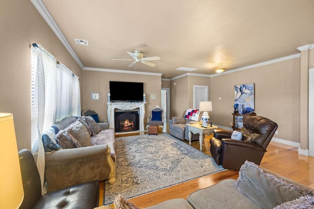 815 James Pl, West Fork, AR 72774 - living room featuring light wood-style floors, ceiling fan, crown molding, a lit fireplace, and baseboards
