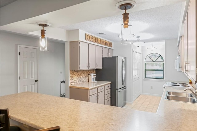 350 S Wildwood Dr Unit C15, Branson, MO 65616 - kitchen with white microwave, freestanding refrigerator, a sink, light countertops, and a textured ceiling
