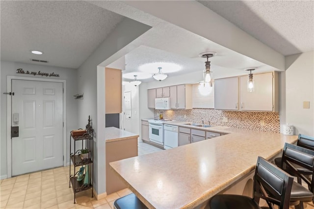 350 S Wildwood Dr Unit C15, Branson, MO 65616 - kitchen featuring white appliances, a textured ceiling, a peninsula, backsplash, and light countertops