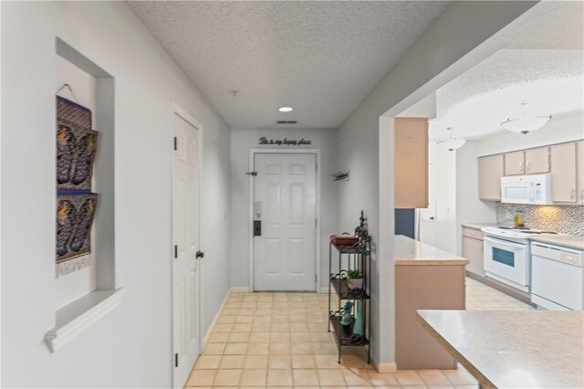 350 S Wildwood Dr Unit C15, Branson, MO 65616 - kitchen with white appliances, a textured ceiling, tasteful backsplash, light countertops, and baseboards