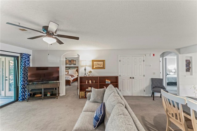 350 S Wildwood Dr Unit C15, Branson, MO 65616 - carpeted living room featuring arched walkways, a ceiling fan, and a textured ceiling