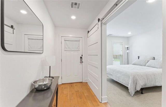 429 SW B St, Bentonville, AR 72712 - bedroom with a barn door, light wood-style flooring, and recessed lighting