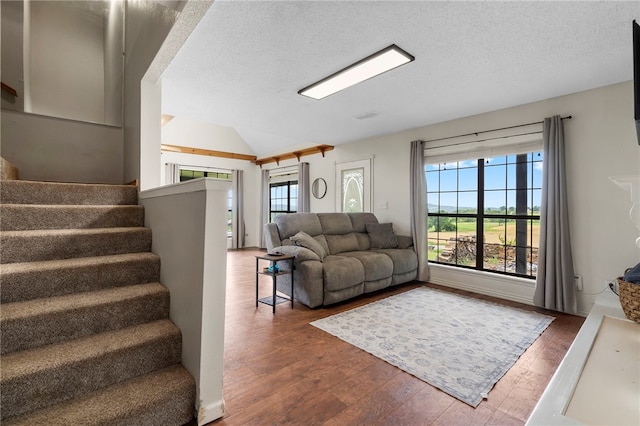 13004 Canehill Rd, Lincoln, AR 72744 - living room with wood finished floors, vaulted ceiling, stairs, and a textured ceiling