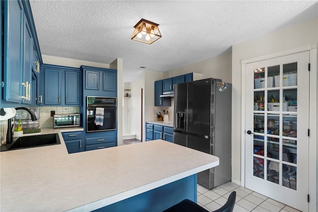 13004 Canehill Rd, Lincoln, AR 72744 - kitchen featuring oven, refrigerator with ice dispenser, a sink, blue cabinets, and a textured ceiling