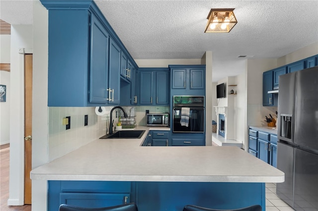 13004 Canehill Rd, Lincoln, AR 72744 - kitchen with appliances with stainless steel finishes, a sink, light countertops, blue cabinets, and a textured ceiling