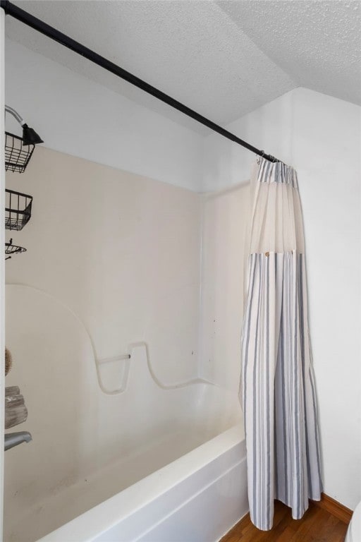 13004 Canehill Rd, Lincoln, AR 72744 - bathroom featuring shower / tub combo with curtain, a textured ceiling, and wood finished floors