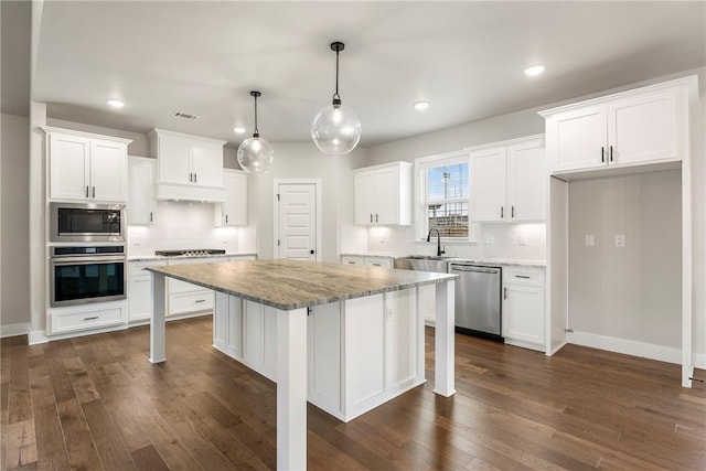 1221 Red Maple St, Centerton, AR 72719 - kitchen with appliances with stainless steel finishes, white cabinetry, under cabinet range hood, dark wood finished floors, and recessed lighting