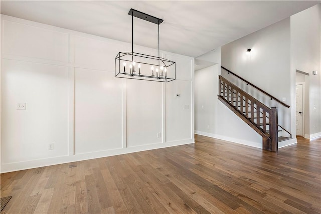 1221 Red Maple St, Centerton, AR 72719 - unfurnished dining area featuring wood finished floors, a chandelier, stairs, and baseboards