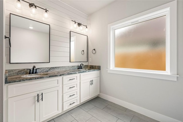 1221 Red Maple St, Centerton, AR 72719 - bathroom featuring double vanity, baseboards, and wooden walls