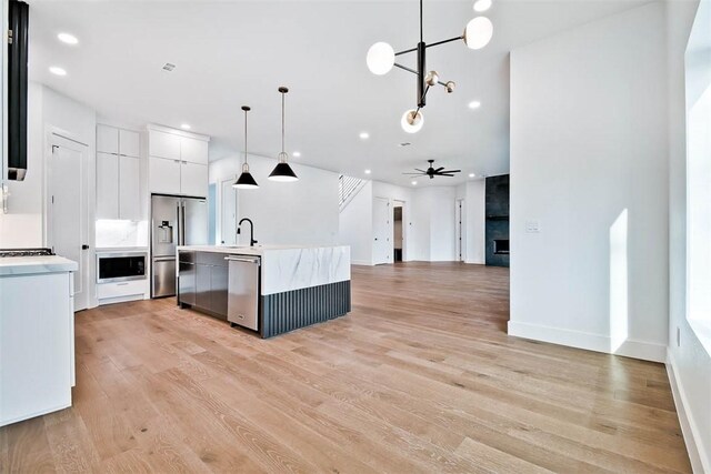 1 Breeghle Ln, Bella Vista, AR 72714 - kitchen with stainless steel appliances, light countertops, light wood-style floors, white cabinets, and recessed lighting