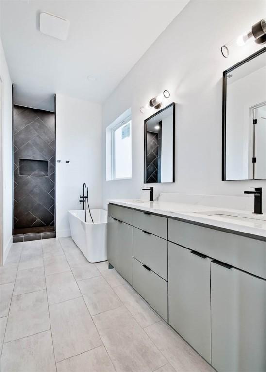 1 Breeghle Ln, Bella Vista, AR 72714 - bathroom with double vanity, a freestanding bath, a tile shower, and tile patterned flooring