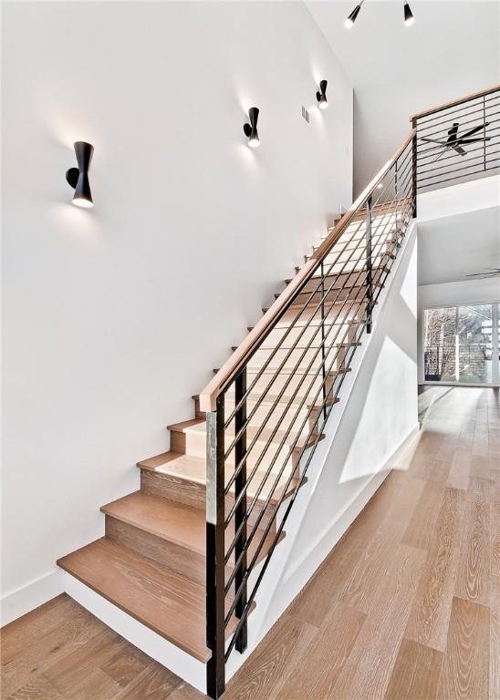 1 Breeghle Ln, Bella Vista, AR 72714 - stairs featuring wood finished floors, a towering ceiling, and ceiling fan