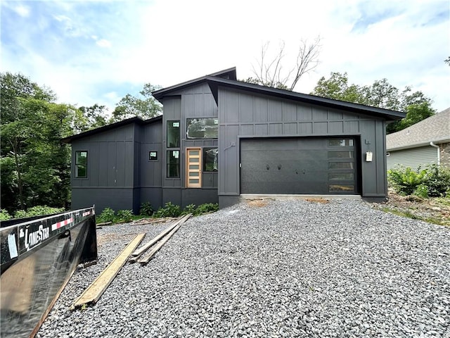 1 Breeghle Ln, Bella Vista, AR 72714 - view of front facade featuring gravel driveway, an attached garage, and board and batten siding
