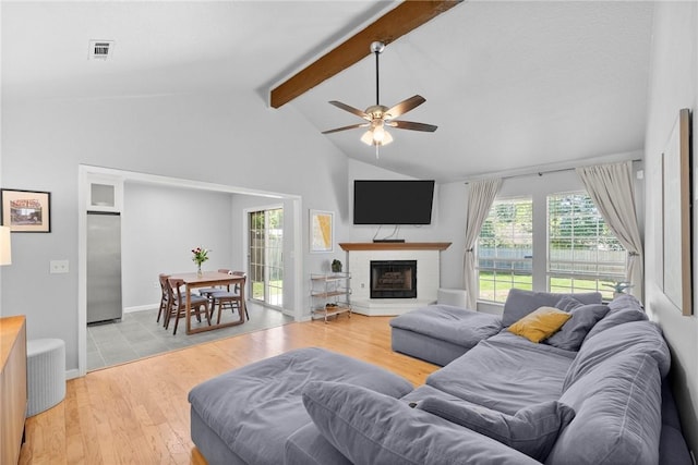 704 Del Cir, Lowell, AR 72745 - living area with beamed ceiling, a fireplace with raised hearth, a ceiling fan, light wood-style flooring, and high vaulted ceiling