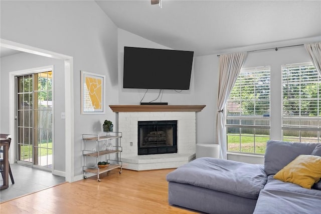 704 Del Cir, Lowell, AR 72745 - living room featuring wood finished floors, lofted ceiling, a fireplace, and baseboards