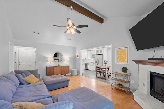 704 Del Cir, Lowell, AR 72745 - living area featuring ceiling fan, beam ceiling, light wood-style flooring, high vaulted ceiling, and a fireplace