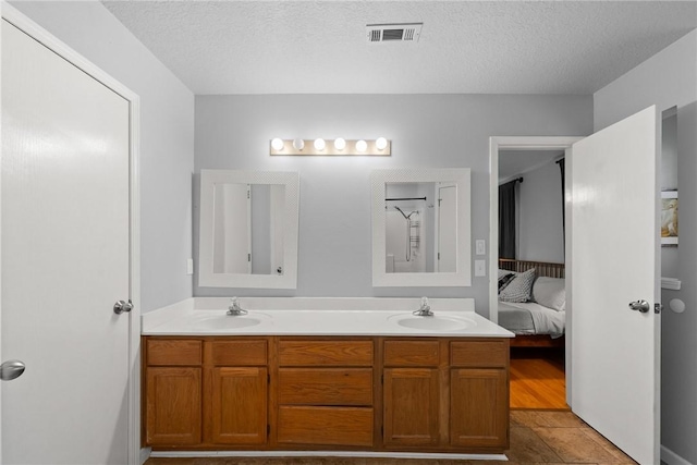 704 Del Cir, Lowell, AR 72745 - ensuite bathroom with double vanity and a textured ceiling