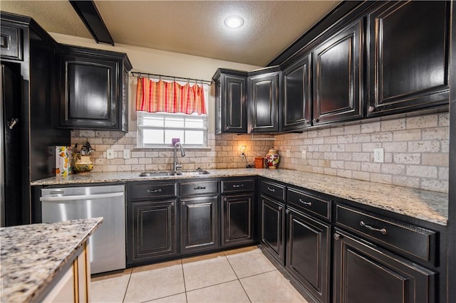 8266 Anna Maria Ave, Springdale, AR 72762 - kitchen with stainless steel dishwasher, dark cabinetry, a sink, decorative backsplash, and a textured ceiling