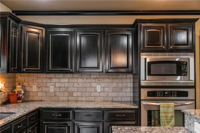 8266 Anna Maria Ave, Springdale, AR 72762 - kitchen featuring stainless steel appliances, backsplash, light stone counters, and dark cabinets