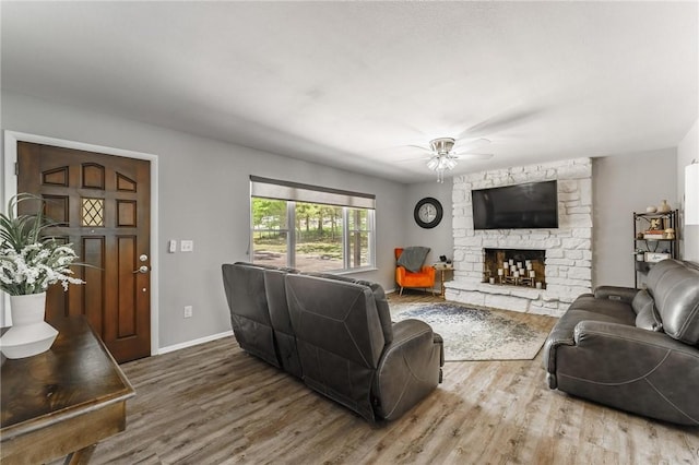 21 Chudleigh Ln, Bella Vista, AR 72714 - living room featuring wood finished floors, a ceiling fan, a fireplace, and baseboards