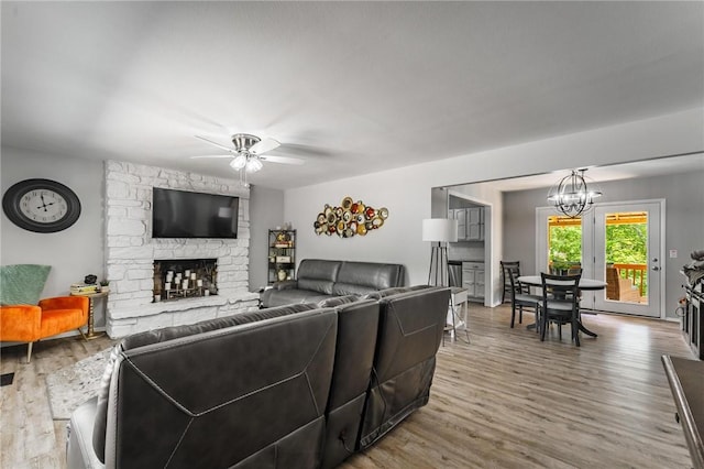 21 Chudleigh Ln, Bella Vista, AR 72714 - living room with a fireplace, wood finished floors, ceiling fan, and a chandelier