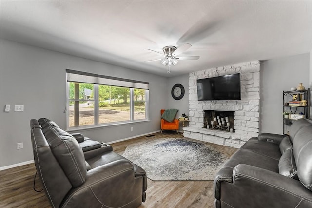 21 Chudleigh Ln, Bella Vista, AR 72714 - living room with a ceiling fan, baseboards, a stone fireplace, and wood finished floors