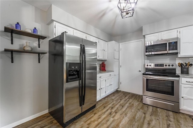 21 Chudleigh Ln, Bella Vista, AR 72714 - kitchen with stainless steel appliances, wood finished floors, white cabinets, open shelves, and light stone countertops