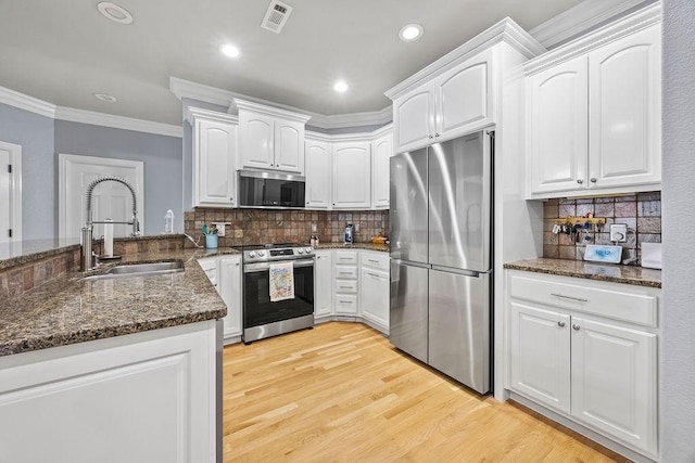6645 Valley View Rd, Rogers, AR 72758 - kitchen featuring appliances with stainless steel finishes, a sink, dark stone counters, ornamental molding, and white cabinets