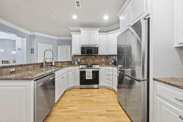 6645 Valley View Rd, Rogers, AR 72758 - kitchen featuring stainless steel appliances, a sink, a peninsula, white cabinetry, and light wood-style flooring