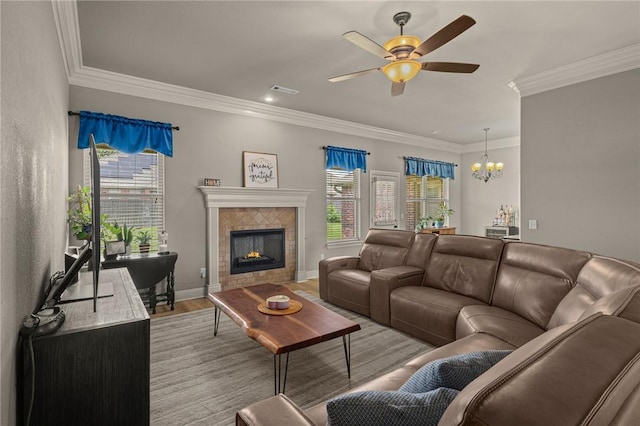 1021 Harvest St, Centerton, AR 72719 - living area with healthy amount of natural light, ceiling fan, crown molding, a tile fireplace, and a chandelier