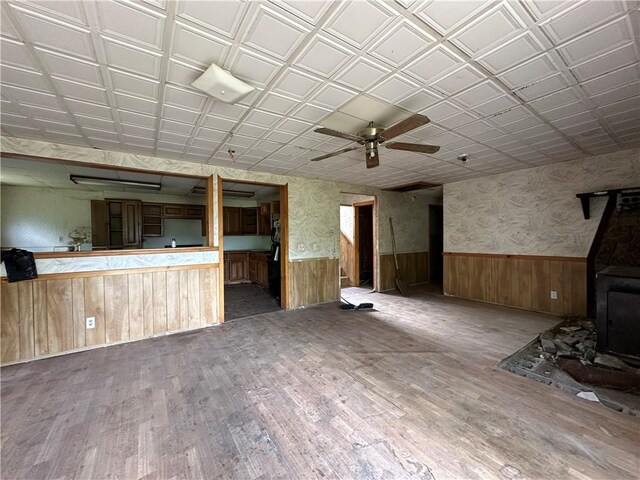 13888 White Oak Ln, Bentonville, AR 72712 - unfurnished living room featuring wainscoting, wood finished floors, a ceiling fan, and wood walls
