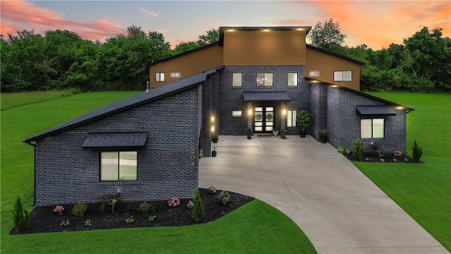 204 NE Healing Springs St, Bentonville, AR 72713 - contemporary house featuring french doors, brick siding, a front yard, and driveway