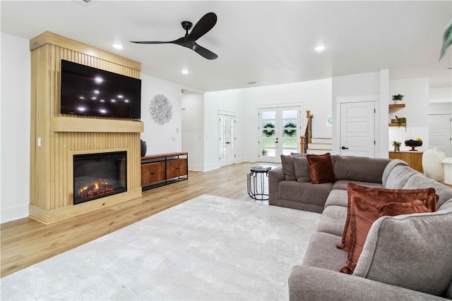 204 NE Healing Springs St, Bentonville, AR 72713 - living room with wood finished floors, stairs, a ceiling fan, a glass covered fireplace, and recessed lighting