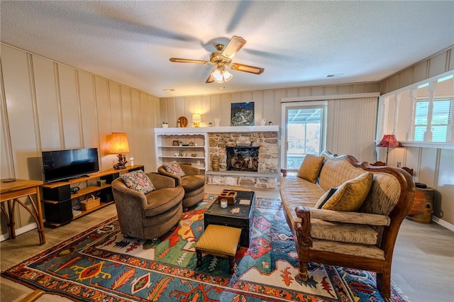 1608 Cartwright Cir, Springdale, AR 72762 - living area with a textured ceiling, a decorative wall, ceiling fan, and a fireplace