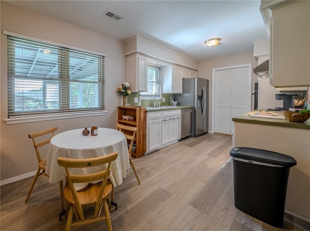 1608 Cartwright Cir, Springdale, AR 72762 - kitchen with stainless steel appliances, a sink, light wood finished floors, and plenty of natural light