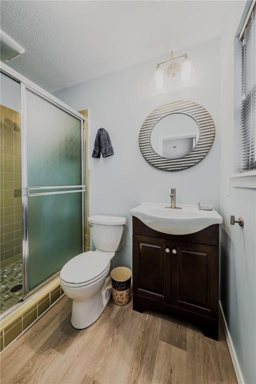 1608 Cartwright Cir, Springdale, AR 72762 - bathroom with vanity, a stall shower, wood finished floors, toilet, and baseboards